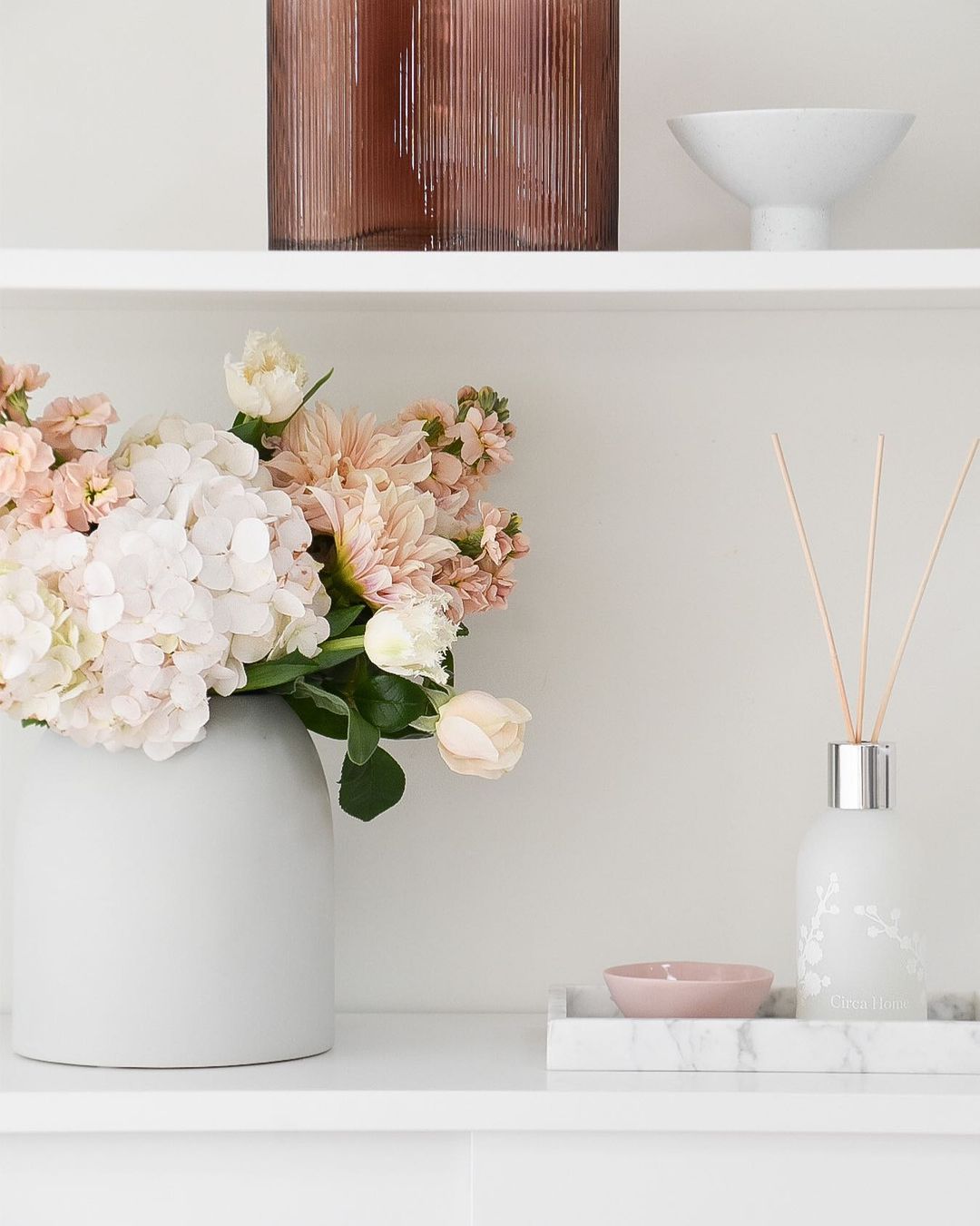 Shelf with Flowers and Oil Diffuser. Photo by Instagram user @coco.camellia_