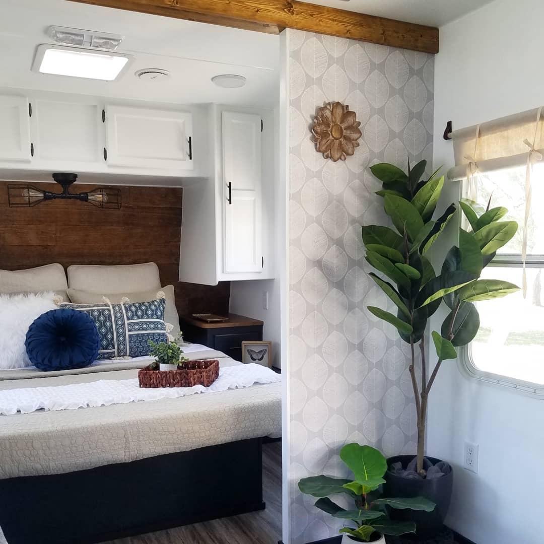 RV bedroom featuring three different plants of varying sizes. Photo by Instagram user @wayland_ventures.