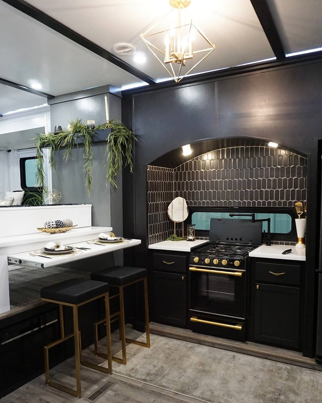 RV kitchen featuring hood lights and statement fixture on the ceiling. Photo by Instagram user @theflippingnomad.