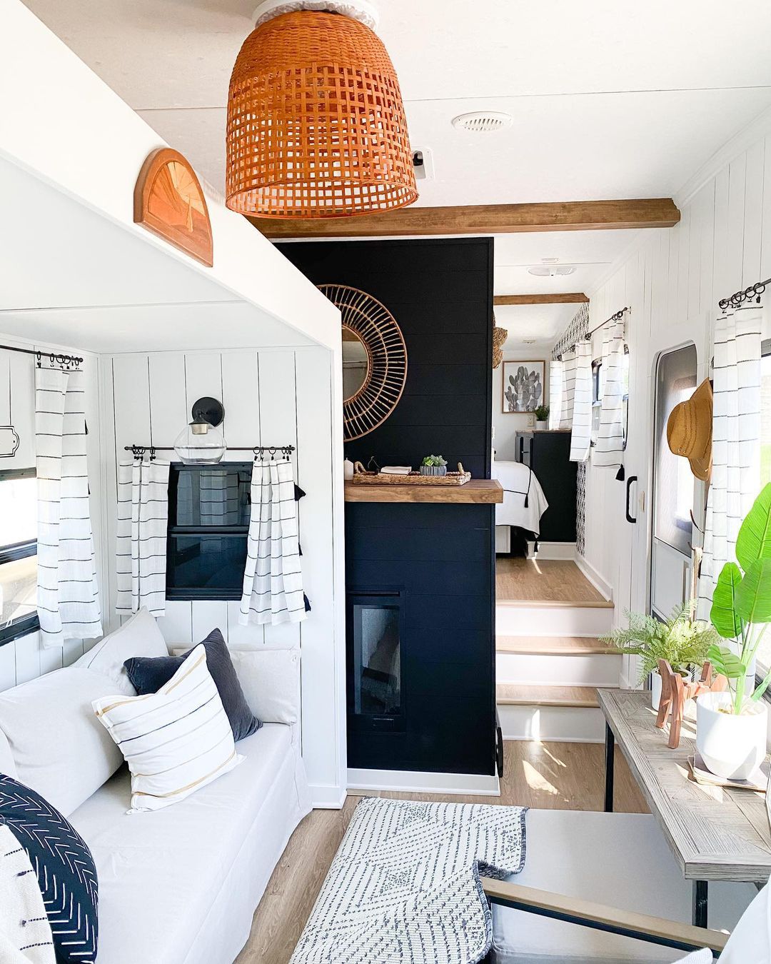 RV interior featuring white walls with a navy accent wall, light pillows and furniture. Photo by Instagram user @wisco_flip.