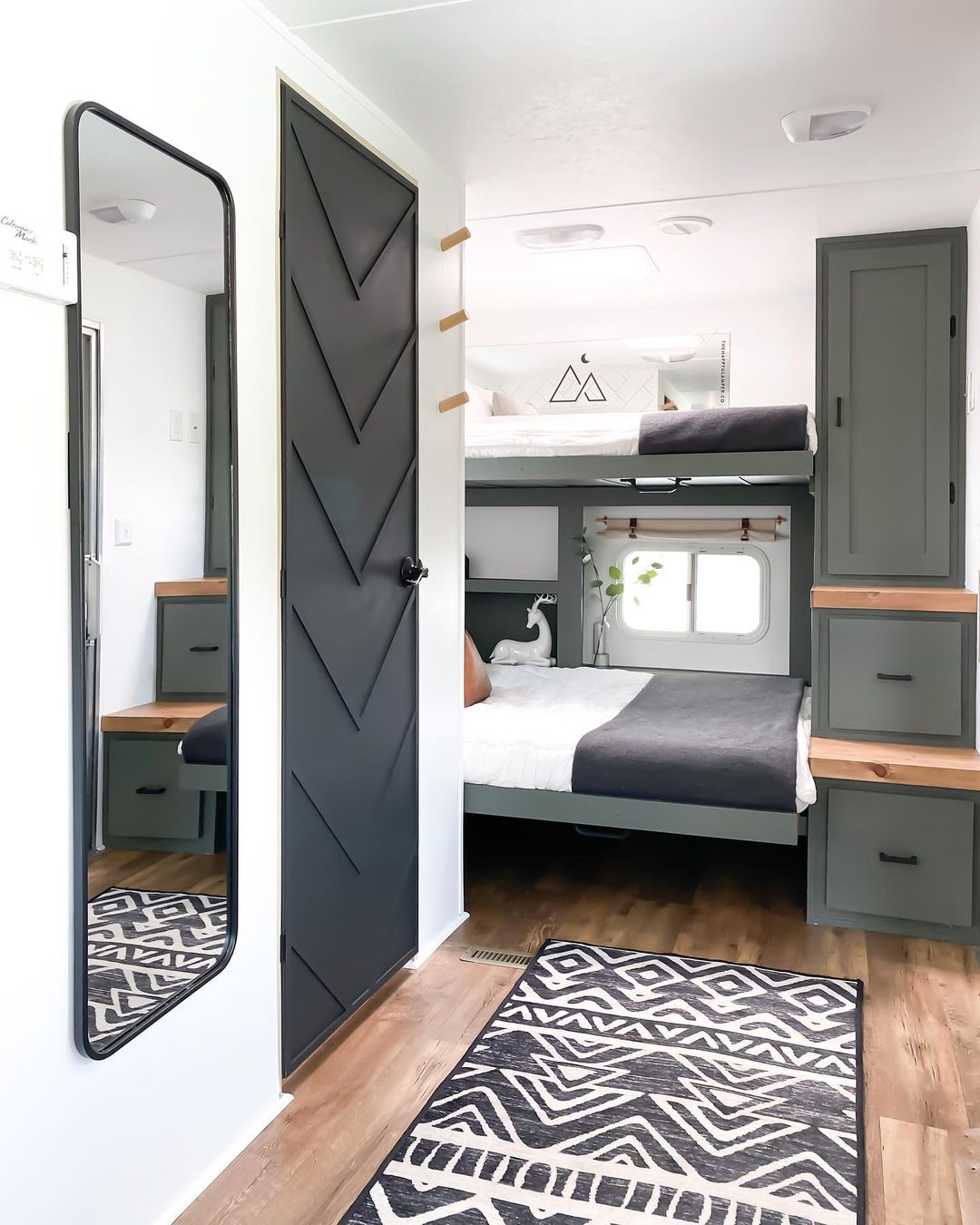 RV bedroom featuring several storage cabinets. Photo by Instagram user @thehappyglamperco.