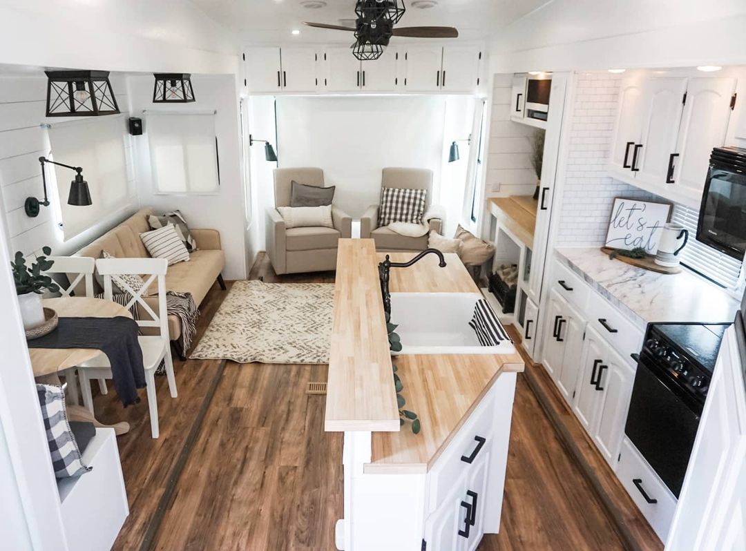 View of extended RV, including kitchenette, dinette, entertainment seating area, multi-use area, and kitchen island with a breakfast bar. Photo by Instagram user @theflippingnomad.