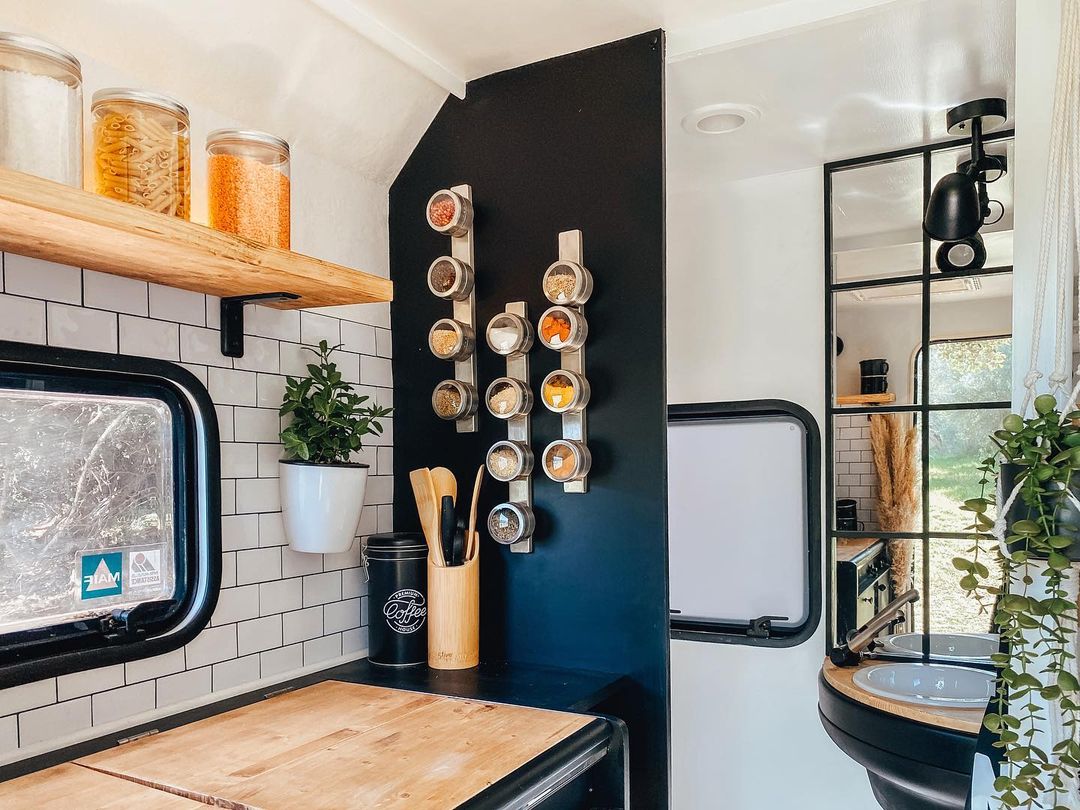 RV kitchen featuring accent wall with magnetic strips for hanging spices. Photo by Instagram user @skyler.thetrailer.