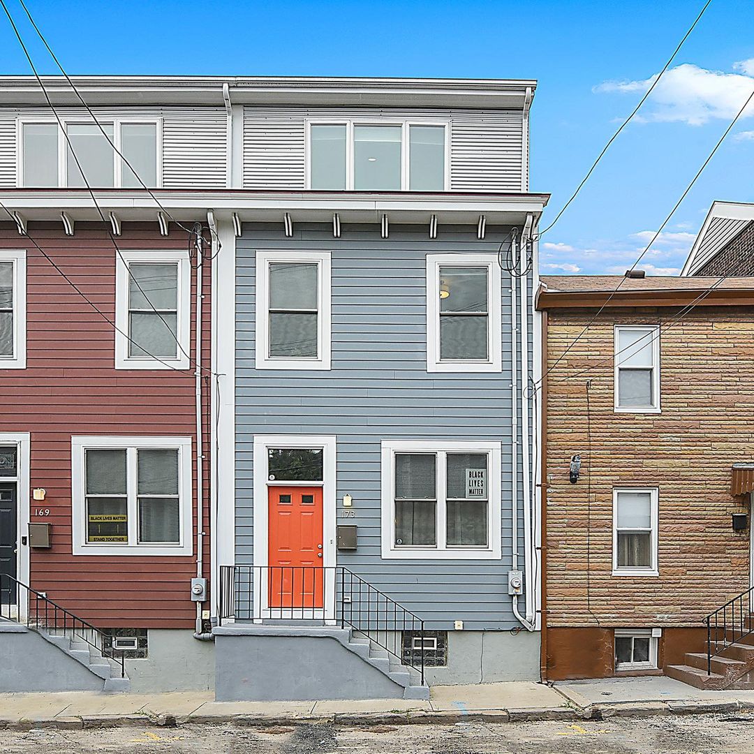 Modern rowhouse with a bright door in Lower Lawrenceville, Pittsburgh. Photo from instagram user @jacoby412