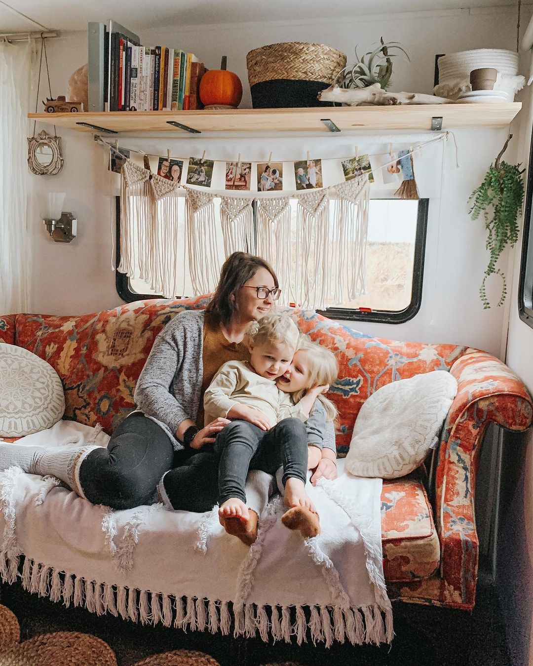 Mom Sitting with Two Kids in an RV. Photo by Instagram user @homestead.on.wheels