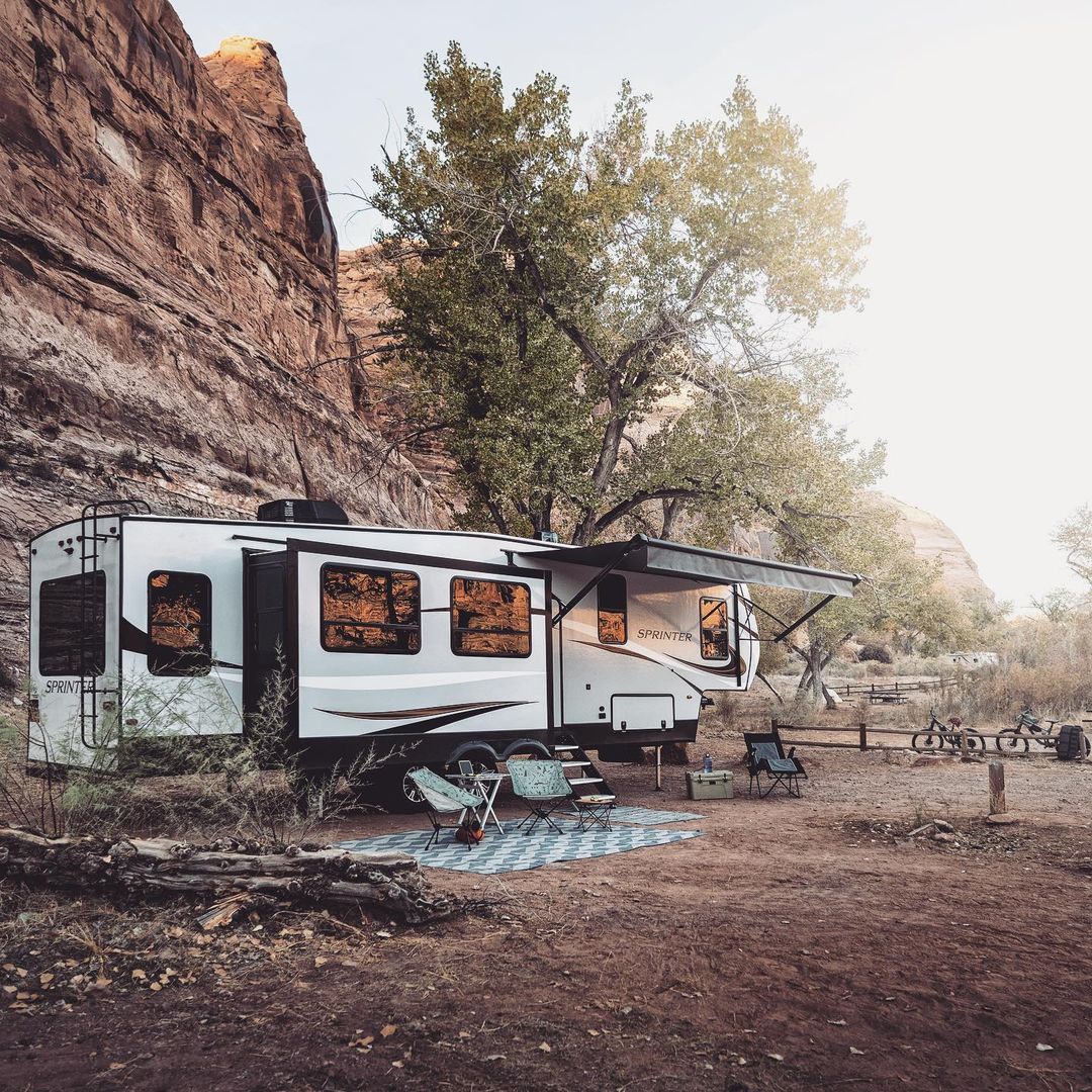 RV set up for camping with rock formations in the background. Photo by Instagram User @keystonervcompany