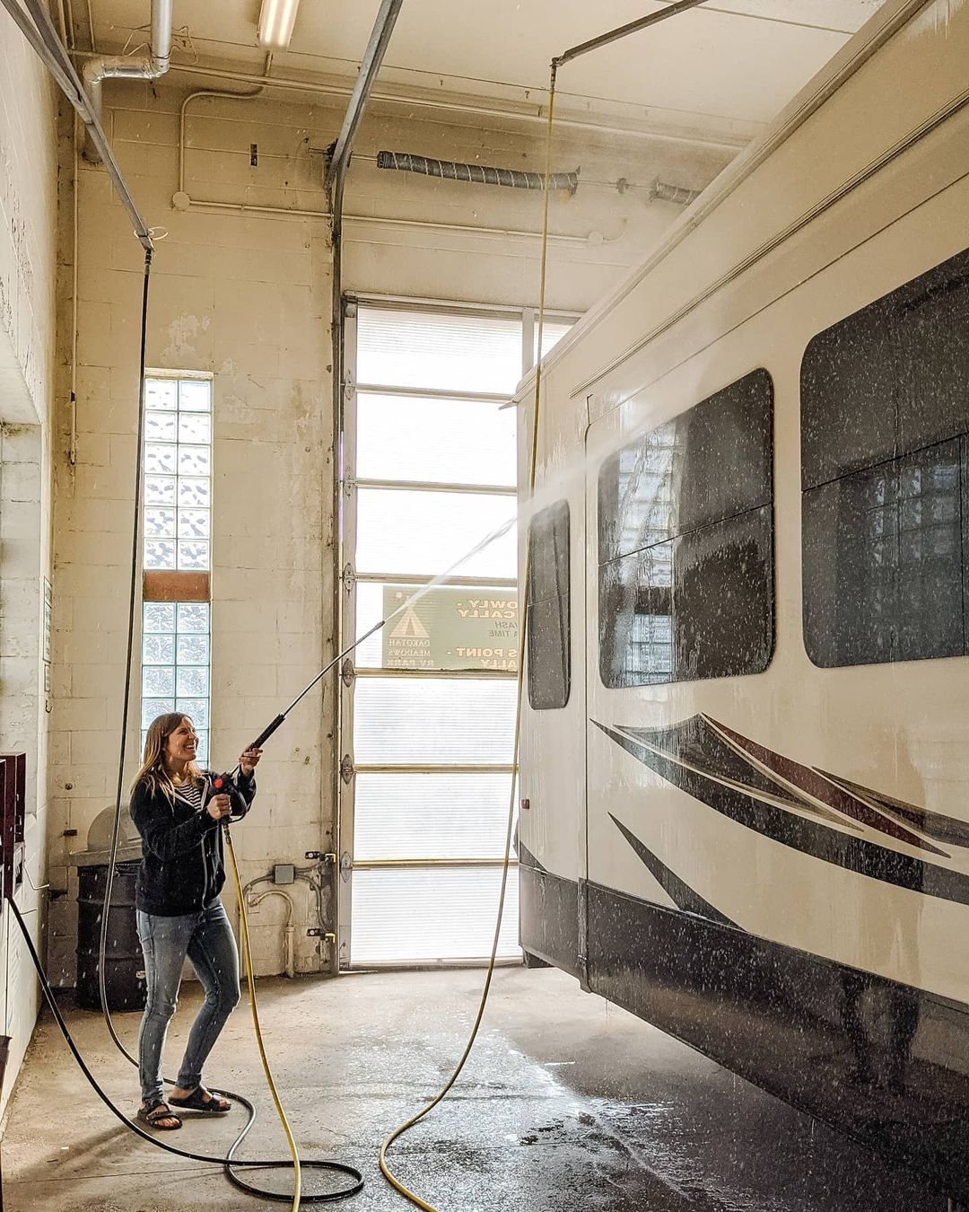 Woman washing her RV with powerful hose. Photo by Instagram User @so.wickesited