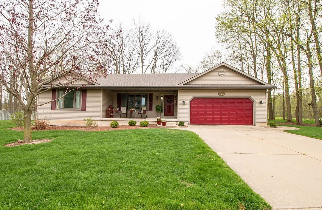 Ranch style home in Grand Ledge Michican with a long driveway and red garage door. Photo by instagram user @macintyrecowenrealestate