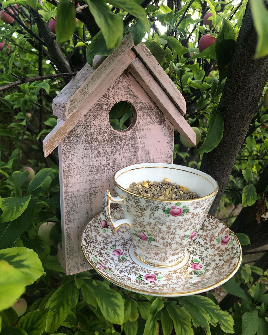Rustic bird feeder made out of neutral wood and a teacup set. Photo by instagram user @vintage_turned_green
