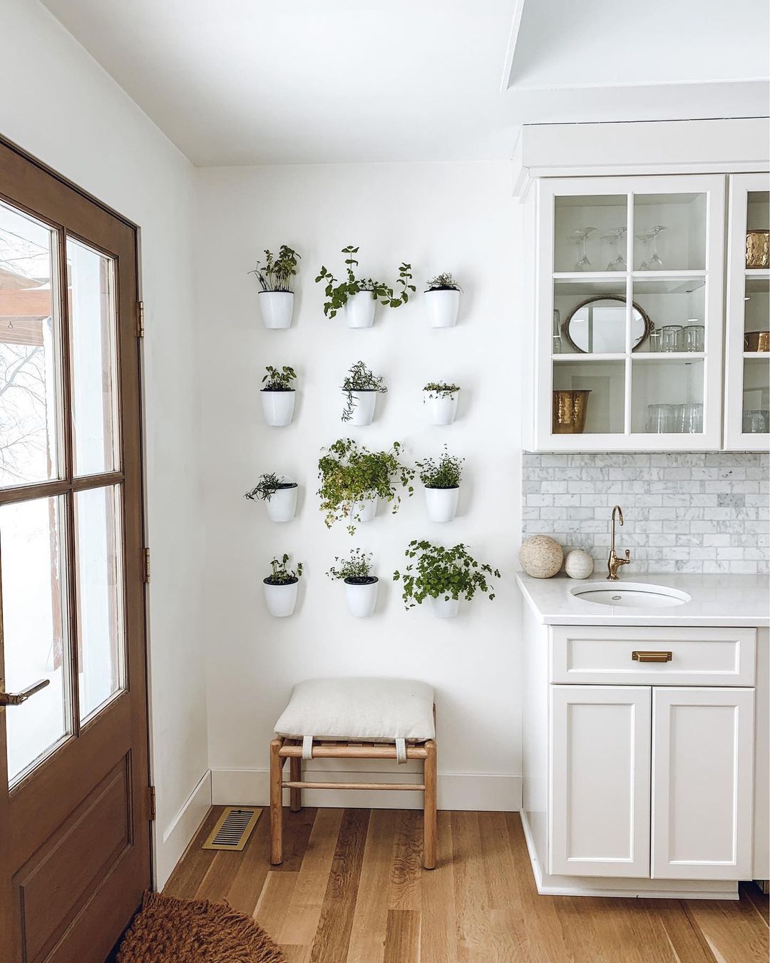 Kitchen wall featuring 12 mounted pots with different herbs growing. Photo by Instagram user @thepenparty.
