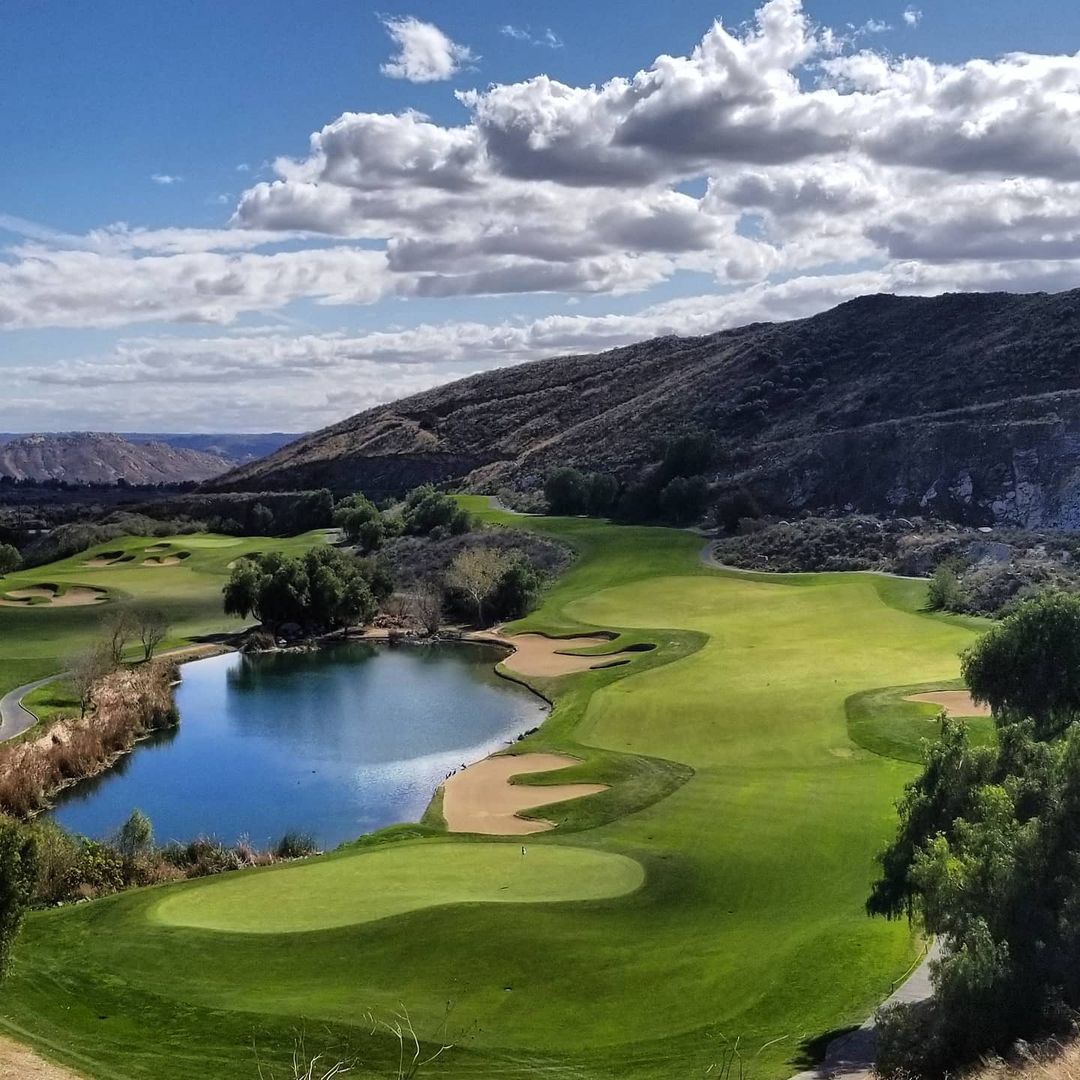 General view of Oak Quarry Golf Club with mountains, water, sandbanks, and healthy green fairway. Photo by Instagram user @oakquarry.