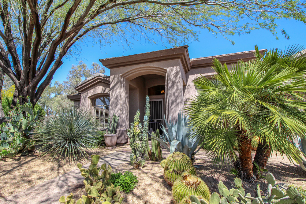 Gorgeous and shady southwestern style home in Phoenix, Arizona with a lot of trees in the front.