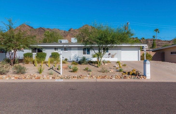 Mid-century modern ranch home in the desert with a rocky front yard and single car garage with a mountain in the background.Photo by instagram user @fifilynn