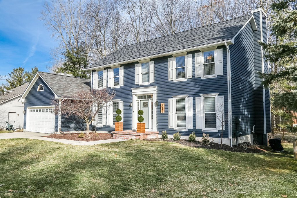 Blue two-story house in Okemos Michican with white trim and shutters. Photo by instagram user @c21lookingglass
