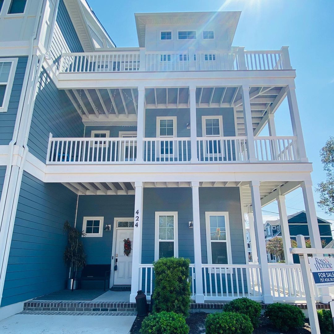 Beautiful blue home with layers of white balconies with a coastal feel and large front porch. Photo by instagram user @757_francesca