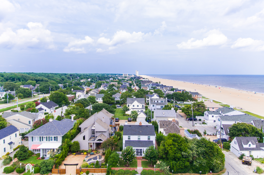 Coastal view of Virginia Beach houses in a neighborhood next to the ocean and a beach landscape.