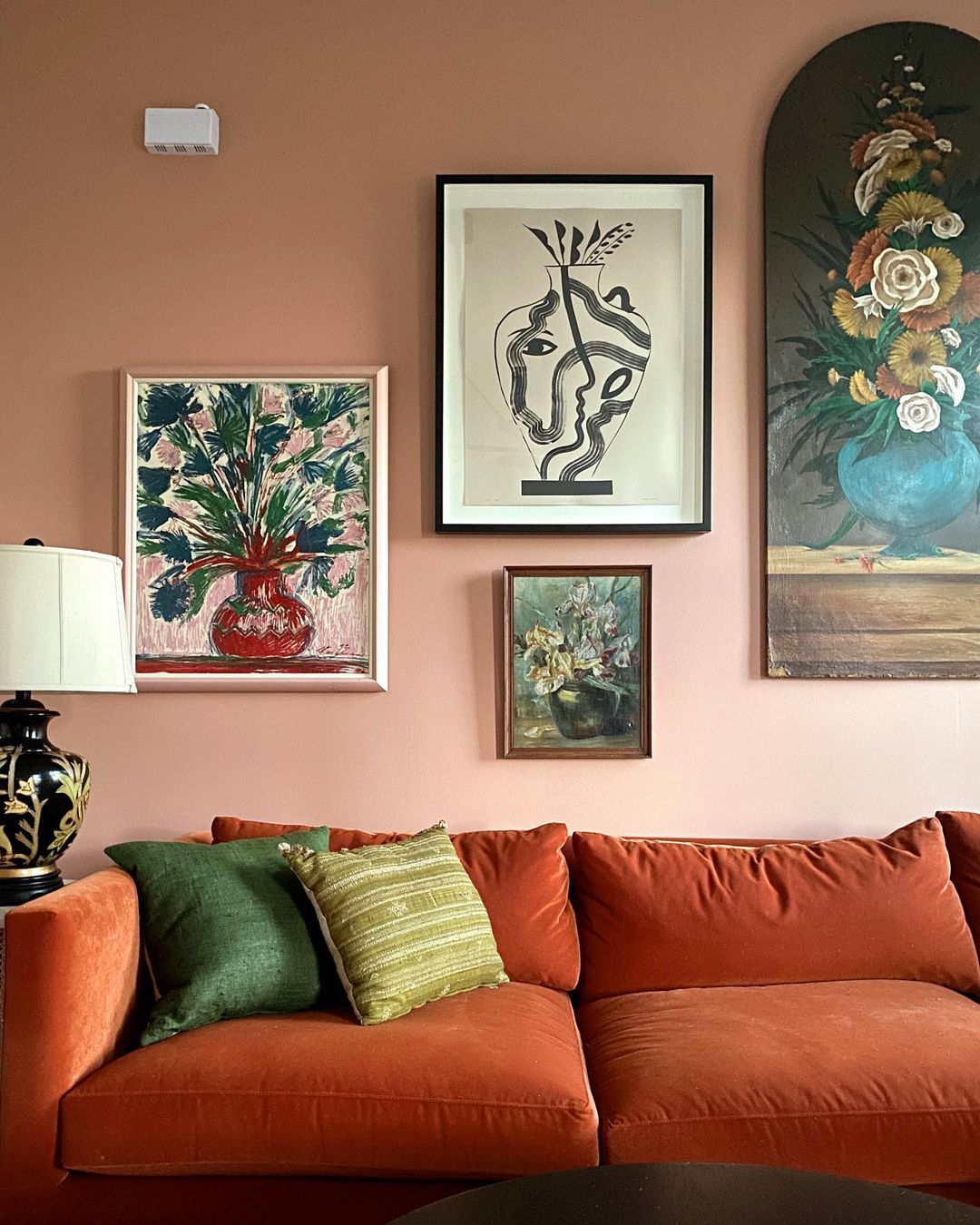 Feng Shui fire element interior design of an Orange couch against a gallery wall. Photo by instagram user @dabito