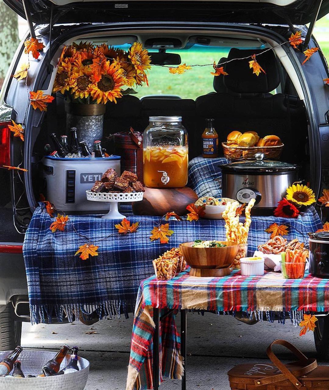 Tailgating food and beverage in the back of an SUV with fall decorations. Photo by instagram user @williamssonoma