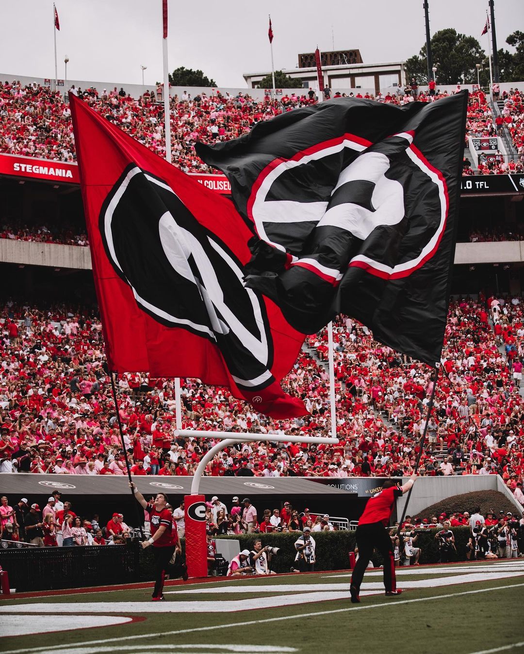 UGA Cheerleaders Running in the Endzone with Large G Flags. Photo by Instagram user @georgiafootball