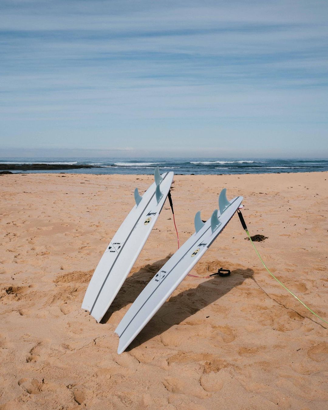 Two Surfboards Stuck into the Sand. Photo by Instagram user @ecsboards_australia