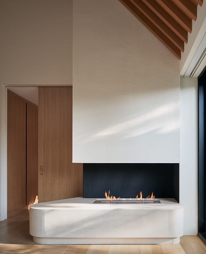Sleek modern home design with angular architecture and a rounded fireplace mantle. Photo by instagram user @mdk_construction