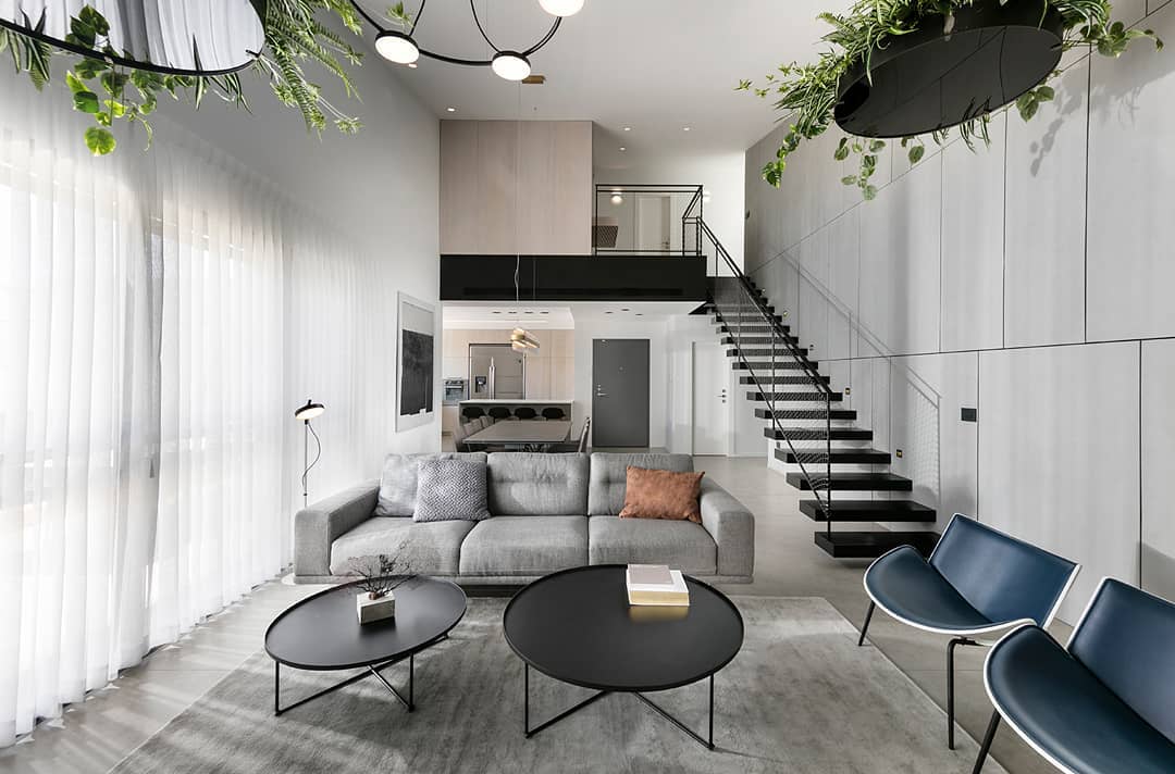 Modern home with concrete walls and sleek design with a steel staircase to a lofted area. Photo by instagram user @studio_erez_hyatt