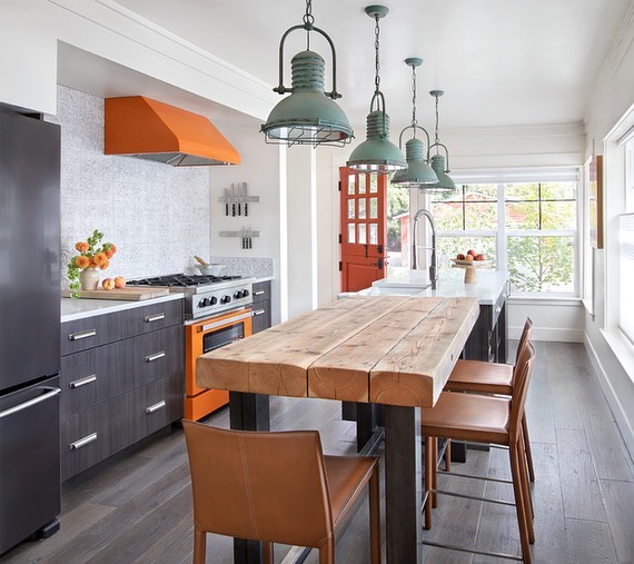 Modern farmhouse kitchen with colorful statement features and appliances with a large wooden table. Photo by instagram user @msldavies