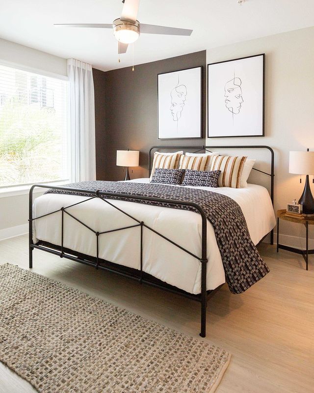 Modern bedroom with bed in bed frame, decorative pillows, and wallart