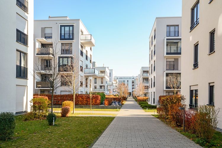 Modern apartment community with paved walkway and landscaping