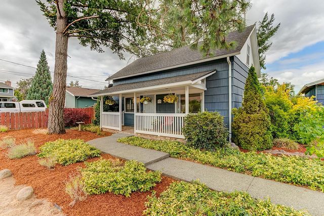 Exterior View of Blue House with a Porch and White Trim.