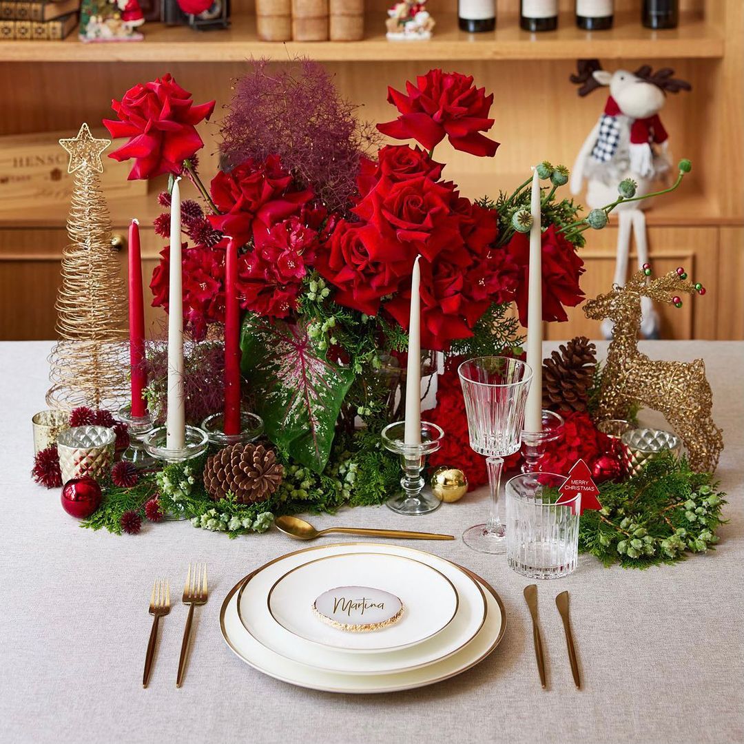 Personalized place setting on a christmas table with a flowery centerpiece and a customized name plate. Photo by instagram user @theprettytablehire