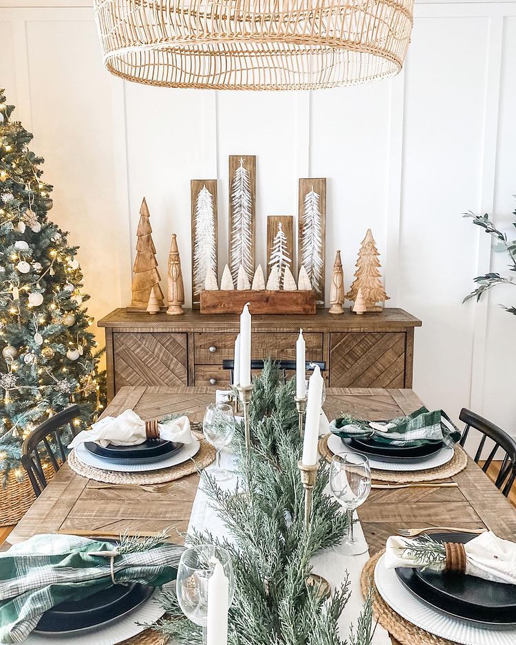 Wooden dining room table set up with garland and holiday decorations throughout the entire room. Photo by instagram user @homemaker_mama
