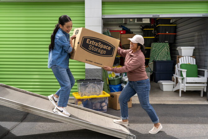 Family moving boxes and items into a storage unit.