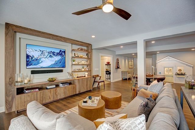 Refinished Basement with Light Wood Tones and Gray Couches. Photo by Instagram user @excel_builders_mn