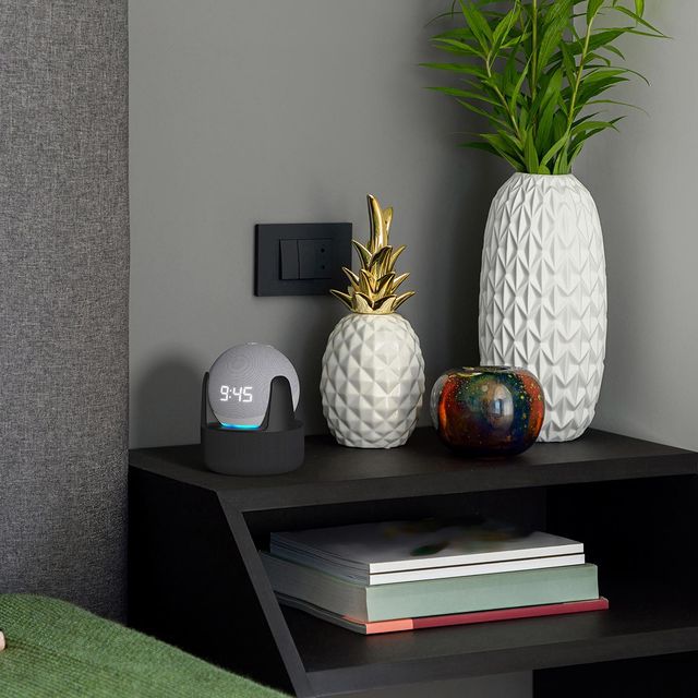 View of modern-black bedside table with decorations and smart technology.