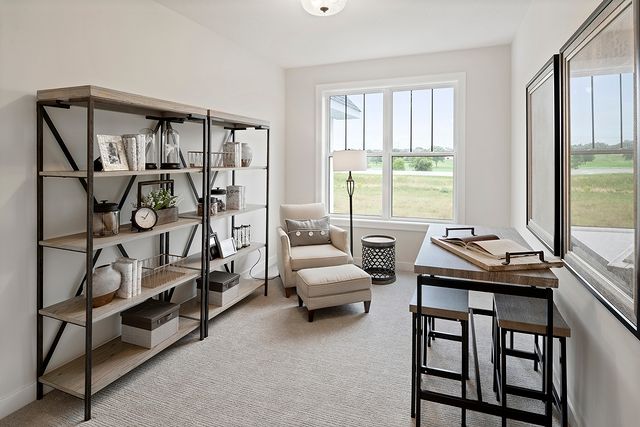 Modern multi-purpose room with book self, chair, and table