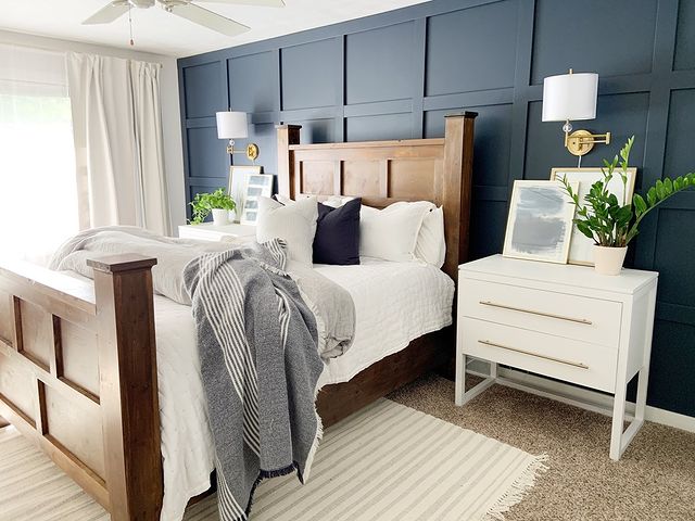Modern bedroom with bed in bed frame, decorative pillows, and an accent wall