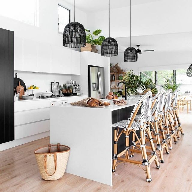 Modern kitchen layout with bar, chairs, and wicker accent lighting