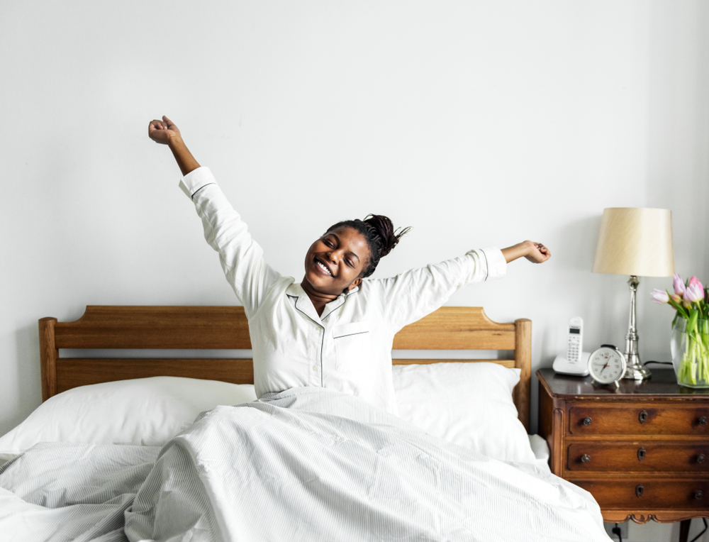 Interior view of a woman waking up in her bedroom with modern furnishings