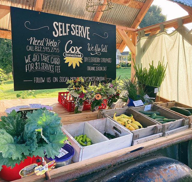 Sign above foods at farmer's market about buying local. Photo by Instagram user @coxhomestead_kodak