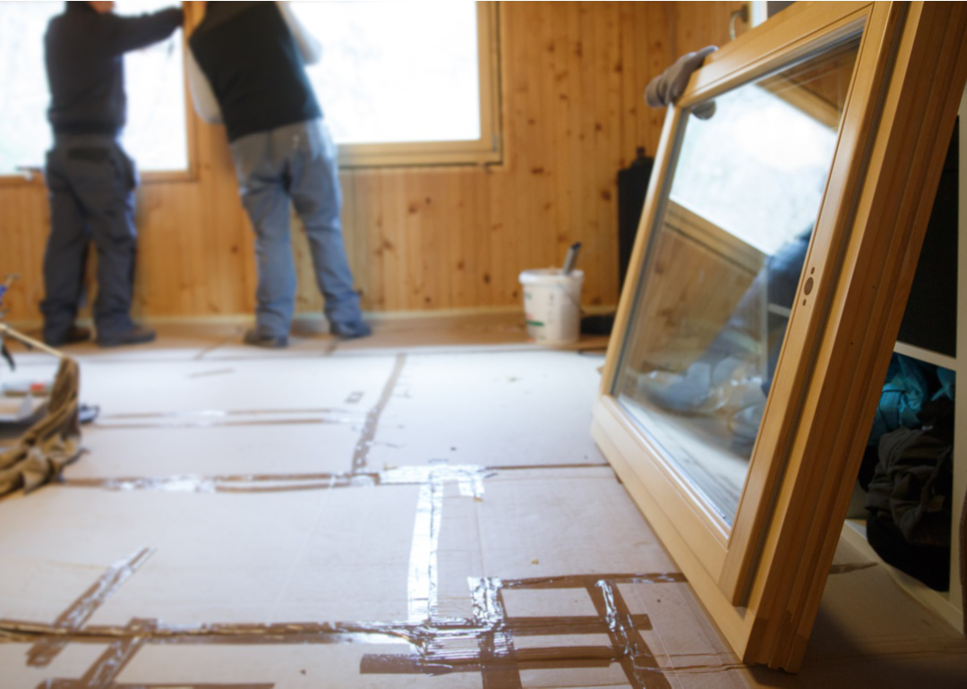 Man preparing to install wooden window in house