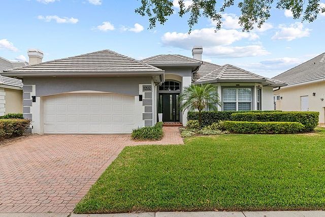 Exterior shot of a white and gray house with a brick driveway in Orlando. Photo by Instagram user @ denileyvaldesrealtor.
