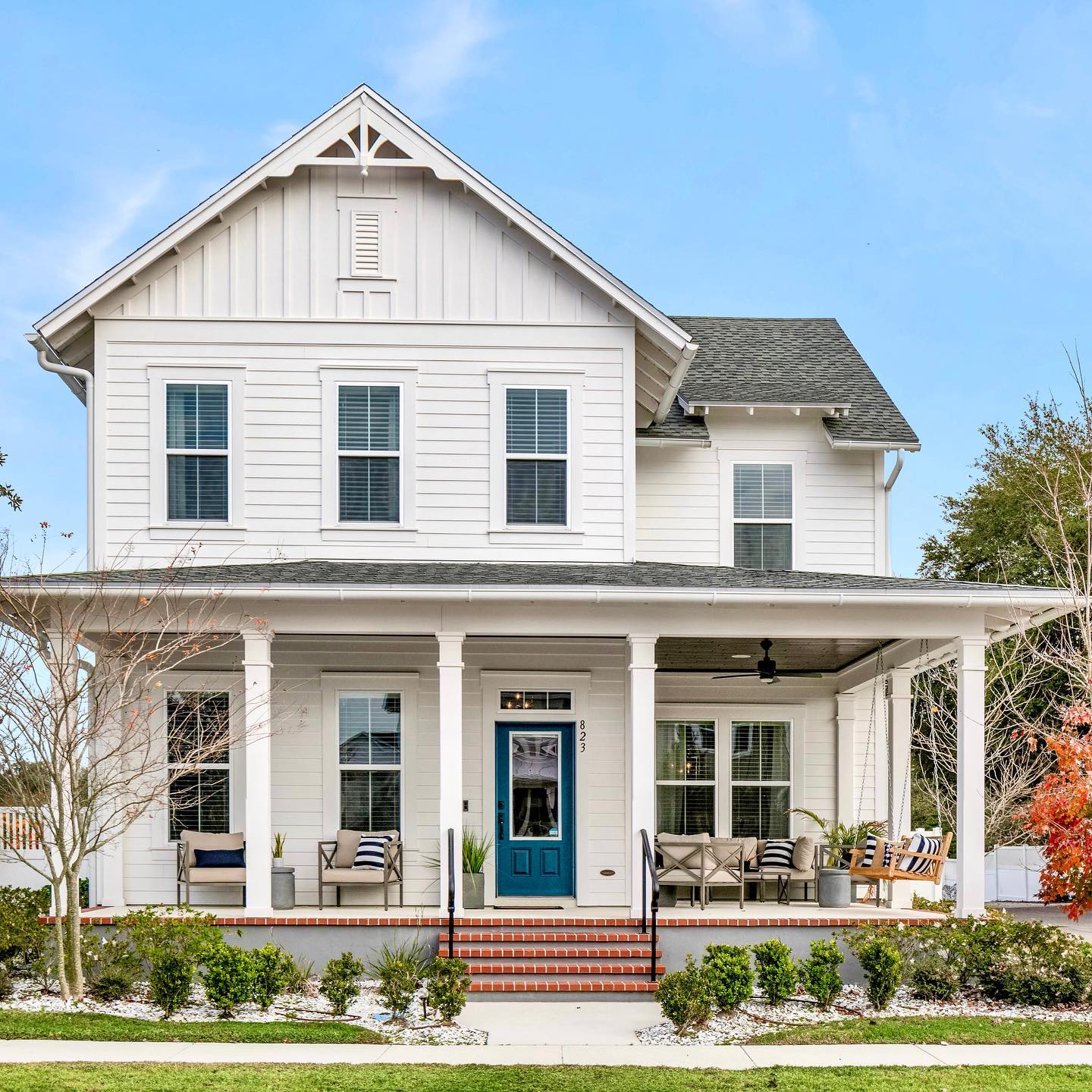 Exterior of a white house in Orlando with a blue door and brick steps leading up to the front porch. Photo by Instagram user @thecorcorangroup.