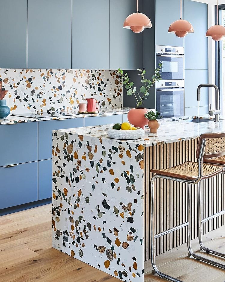 Kitchen interior with blue cabinets and terrazzo countertops. Photo by Instagram user @diespeker.co.