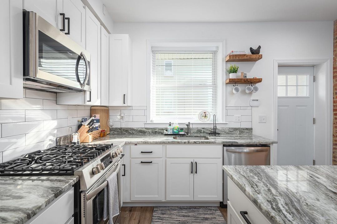 Kitchen interior with granite countertops and white cabinets. Photo by Instagram user @donovanphotography.