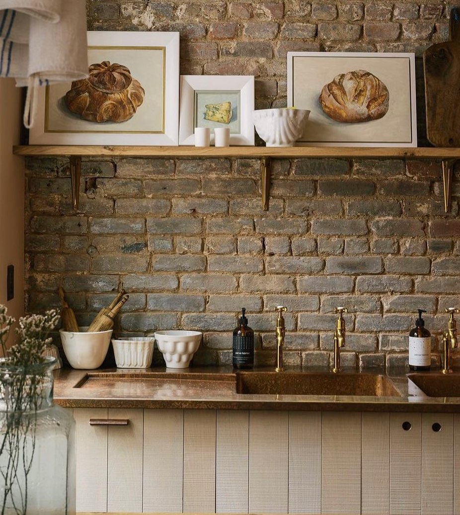 Kitchen with copper countertop and brick wall. Photo by Instagram user @jillandco.interiors.