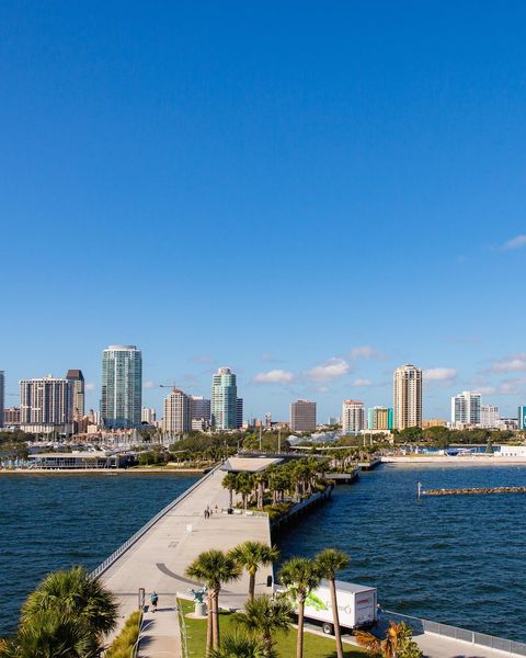 Beach boardwalk with city view in background of St. Petersburg, FL. Photo by @stpetefl