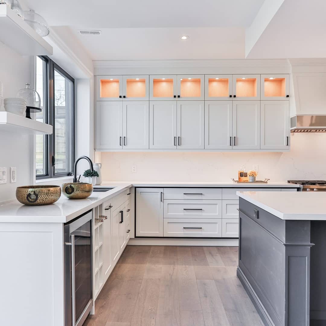 White cabinets with upper-cabinet displays. Photo by Instagram user @thecabinetchic