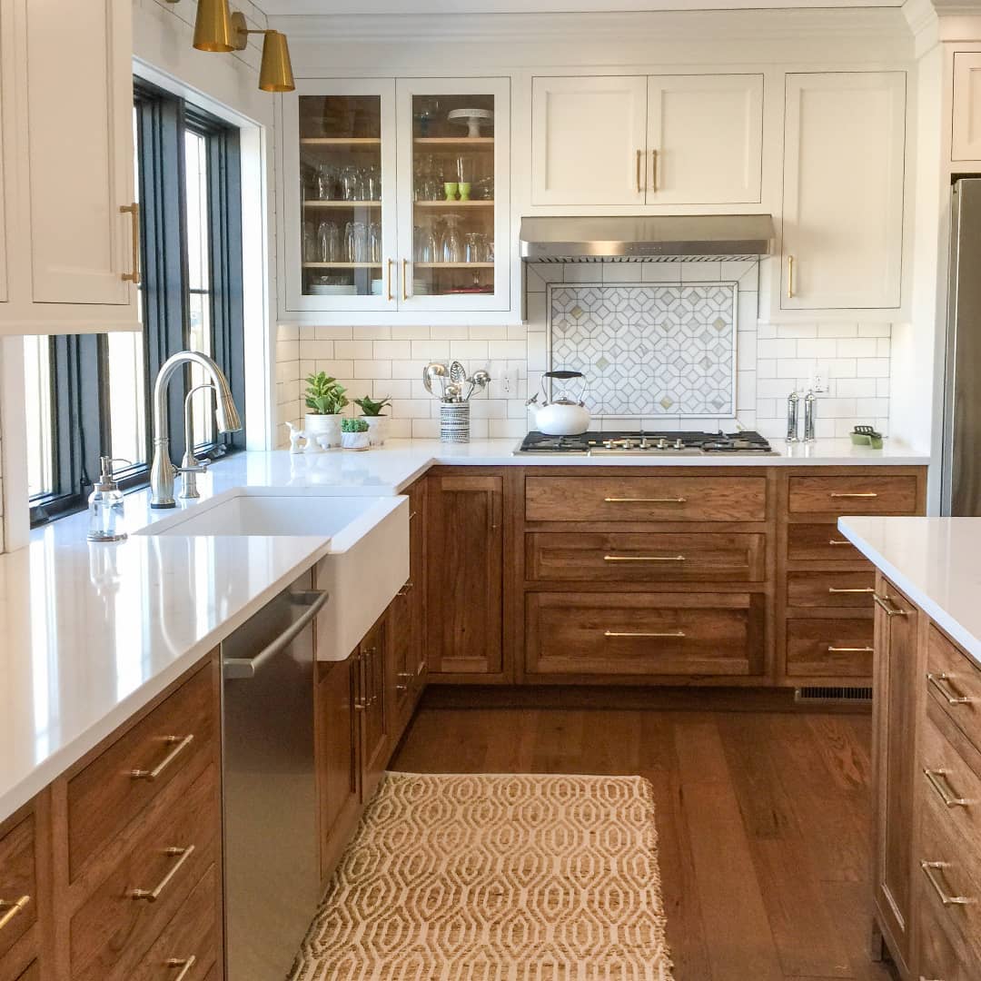 Lighter stained high cabinets and darker stained lower cabinets in kitchen. Photo by Instagram user @cabinetjoint