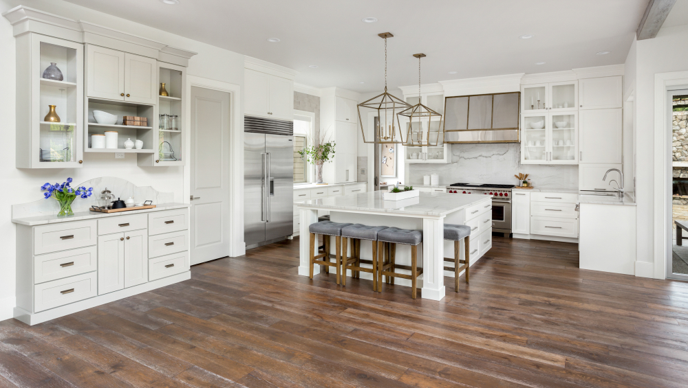 Large kitchen interior with white cabinets and wood floors